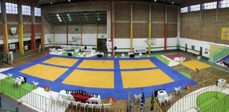 Gin&aacute;sio montado com m&uacute;ltiplas &aacute;reas de tatame azul e amarelo